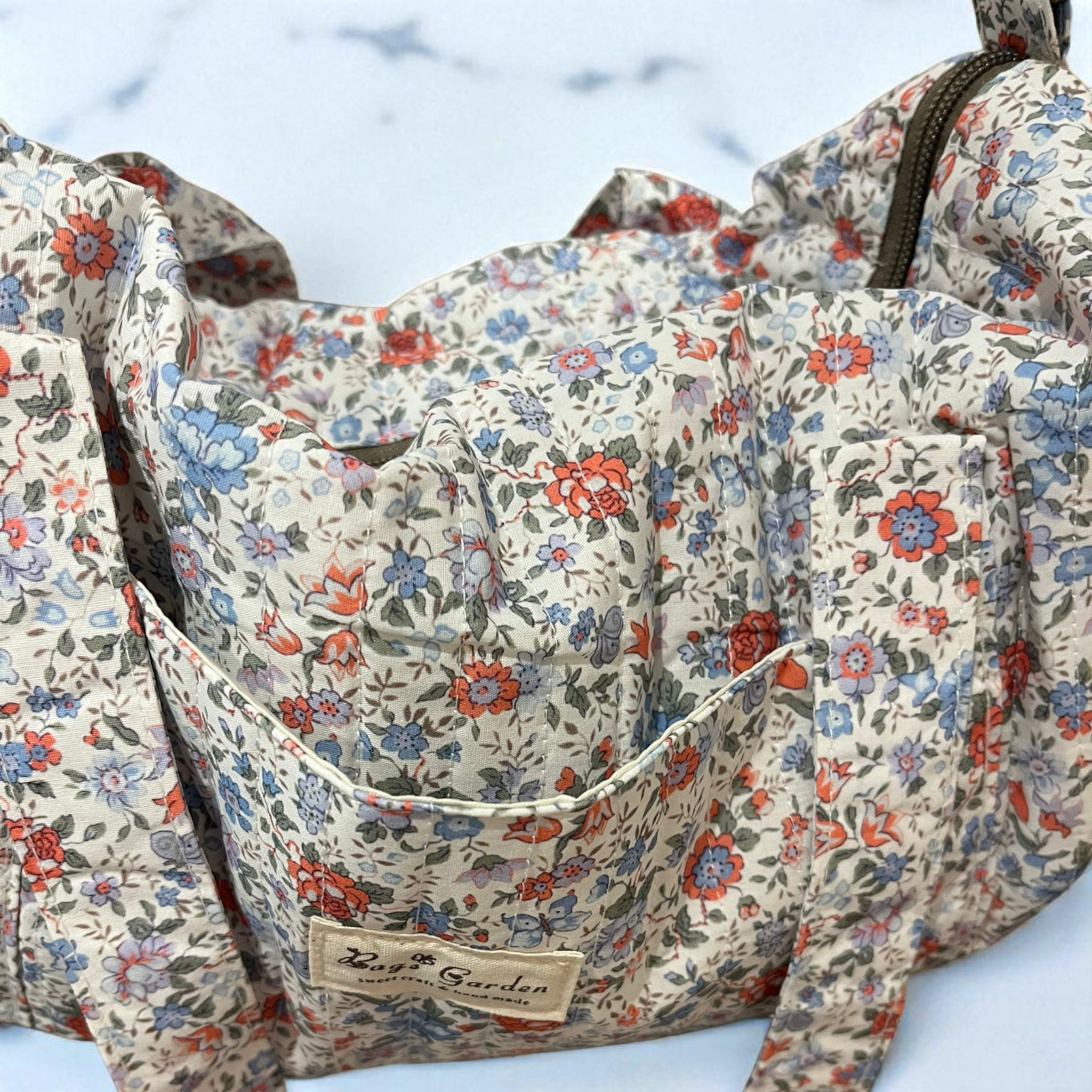 LIBERTY-  Bolsa de viaje acolchada Flores azules y naranjas